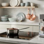 “Close-up of modern induction, an immersion blender, and a sous vide circulator in a French-inspired kitchen counter setup.”