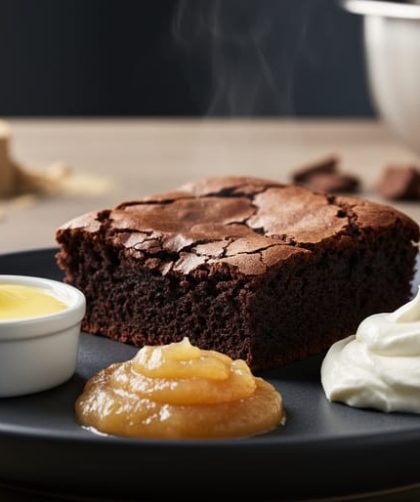 Fudgy brownies on a dark plate with ramekins of melted butter, applesauce, and Greek yogurt beside them to represent oil substitutions for texture.